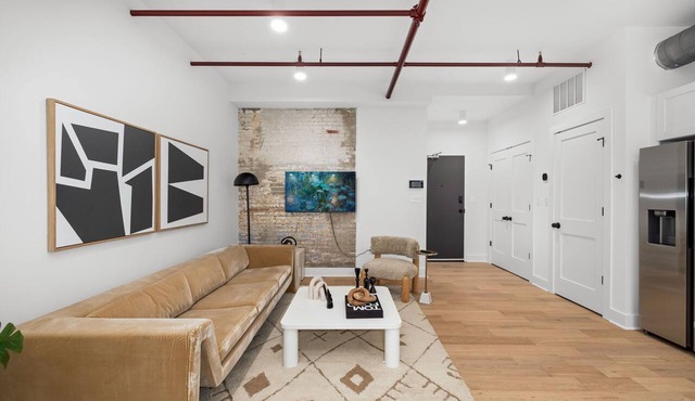 Design-forward flat in Old Town's most iconic building. Exposed brick, bold red ceiling pipes, corner bedroom bathed in natural light. Modern kitchen, quiet side street. Steps from 100+ restaurants & waterfront. A LovableBNB Collection listing. in Alexandria